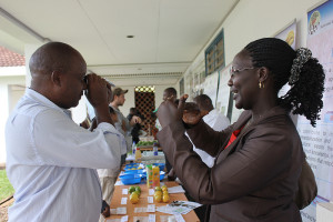 Charity Gathambiri, of KARI, shows an event participant how to use a refractometer to measure sugar levels of tomatoes at the new center. Gathambiri also completed Horticulture CRSP’s year-long postharvest training in Tanzania.